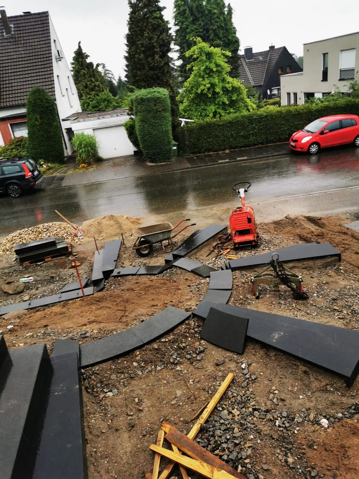 Setzen geschwungener Blockstufen im Vorgarten während der Bauphase