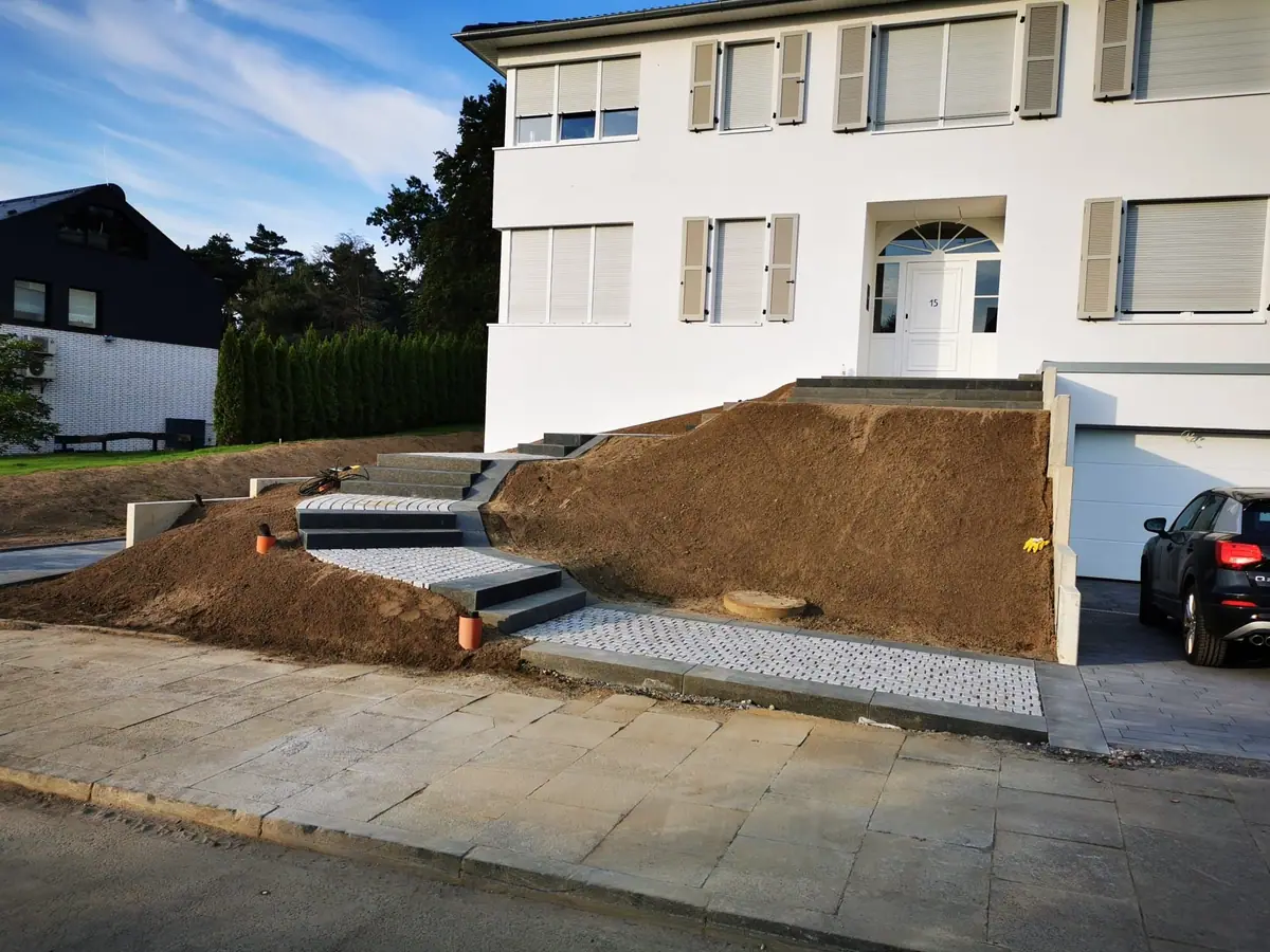 Hauseingang am Hang mit neuen Blockstufen und Granitpflaster während der Bauphase