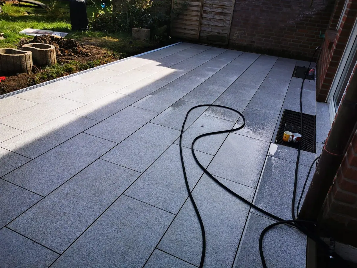 Frisch gereinigte Terrasse aus Granitplatten im Reihenhausgarten